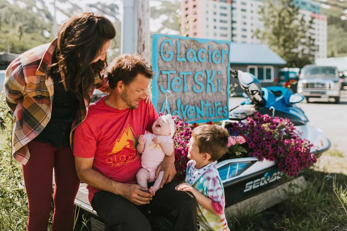 Family with baby near jet ski sign