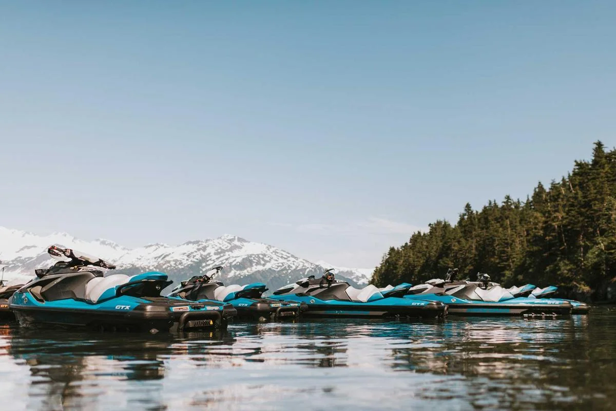 Three jet skis near trees